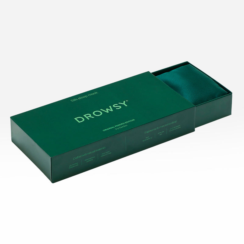 An Ivy Garden green silk sleep mask inside an open green gift box, perfect for beauty sleep.
