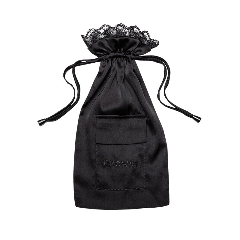 Introducing the Paris Love Story Carry Pouch by drowsysleepco: a black satin drawstring bag featuring couture-inspired lace trim, a convenient front pocket embroidered with “DROWSY,” and designed to beautifully complement your favorite silk sleep mask—all showcased against a white background to evoke the timeless elegance of a Paris Love Story.