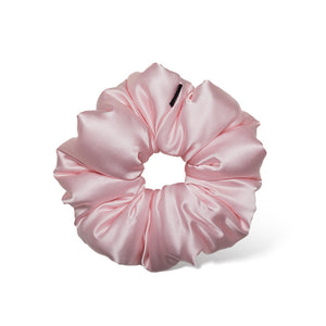 The Petal Pink Padded Scrunchie by us.drowsysleepco is an oversized, shiny satin hair accessory in light pink, displayed on a white background. Its smooth gathered design ensures comfort and supports hair health.