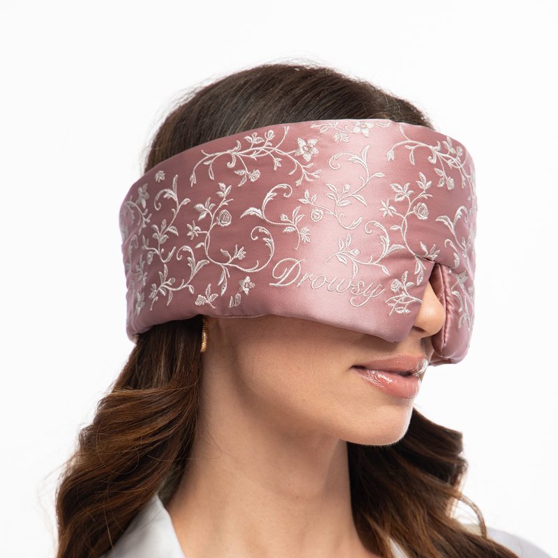 A dusty pink Pride & Prejudice - English Rose Sleep Mask featuring an embroidered white floral pattern and script text.