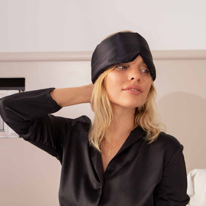 Model in bed with Black Jade coloured Drowsy Sleep Co Silk mask resting on her head