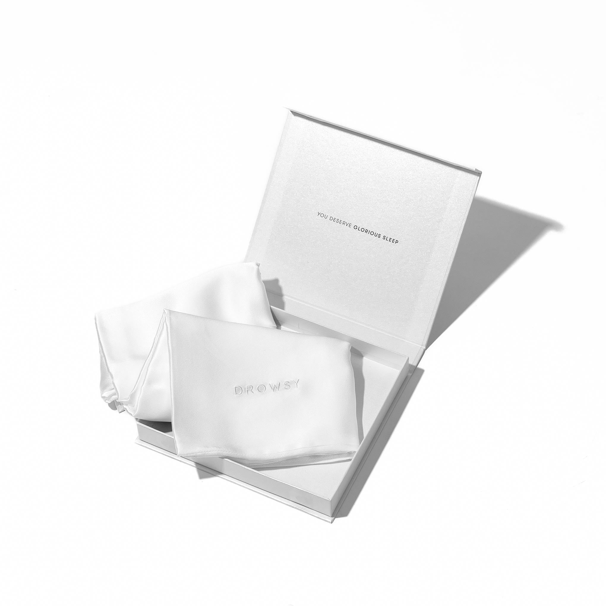A Jasmine Cushion Cover by drowsysleepco displayed in an open white gift box with "YOU DESERVE GLORIOUS SLEEP" inside the lid. The cushion cover is neatly arranged on a white background.