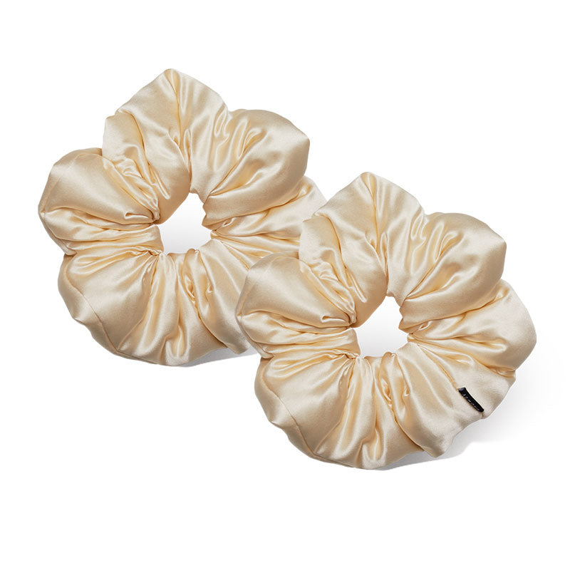 The us.drowsysleepco Champagne Gold Padded Scrunchie features oversized, light beige silk with a smooth, shiny finish. Its gathered design adds volume and offers an effortlessly chic look, shown here against a white background.