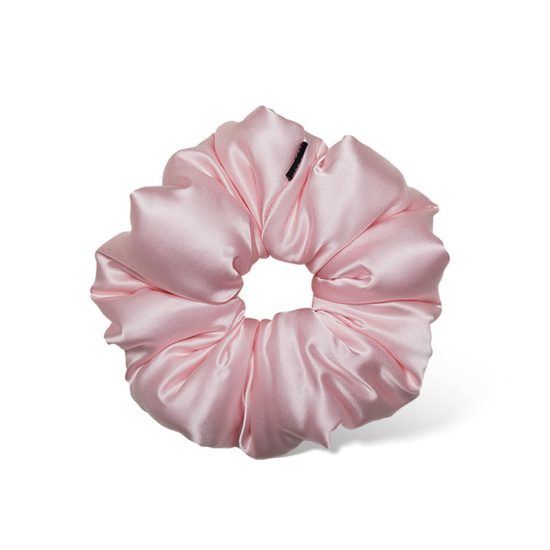 The Petal Pink Padded Scrunchie by us.drowsysleepco is an oversized, shiny satin hair accessory in light pink, displayed on a white background. Its smooth gathered design ensures comfort and supports hair health.