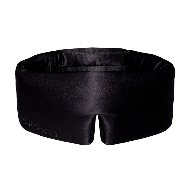 The Black Jade by drowsysleepco is a black silk, contoured eye mask with a subtle notch at the bottom center. “DROWSY” is elegantly embossed on the lower left, making it a stylish blackout sleep mask designed for beauty rest.