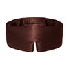 A woman with short brown hair wears the Rajah Sleep Mask by drowsysleepco on her head. She looks down calmly, dressed in a beige top and a silver necklace.
