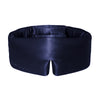A woman in a white shirt relaxes on white sheets with sunlight streaming in, wearing the drowsysleepco Perfect Escape Bundle - Midnight Blue sleep mask embroidered with 